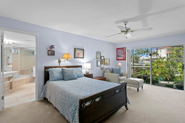 bedroom featuring ceiling fan, light colored carpet, connected bathroom, and a textured ceiling