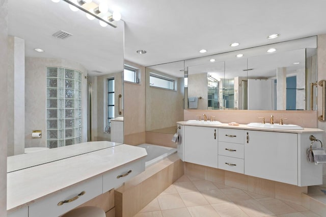 bathroom featuring vanity, tile patterned floors, and tiled bath