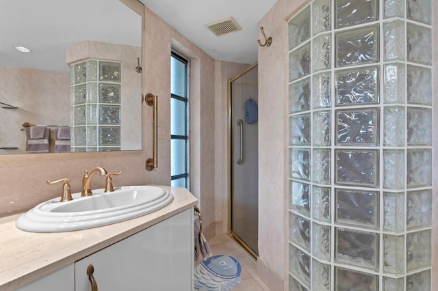 bathroom with vanity, tile patterned floors, and tiled shower