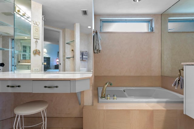 bathroom with vanity and tiled bath