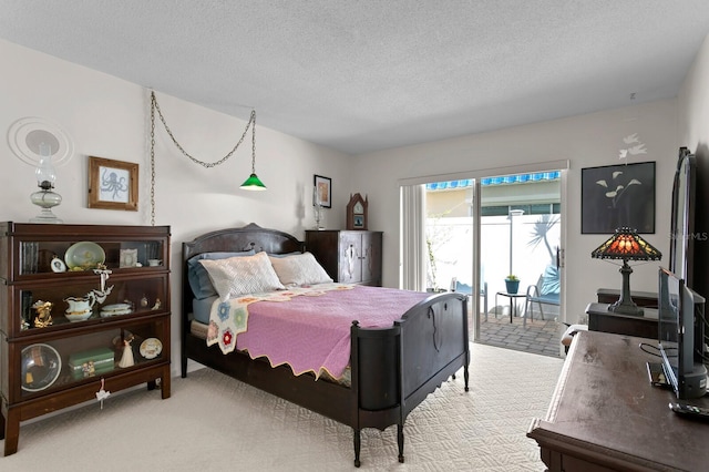 carpeted bedroom featuring access to exterior and a textured ceiling