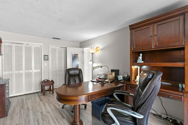 office featuring a textured ceiling and light hardwood / wood-style floors