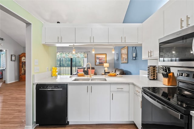 kitchen with sink, white cabinetry, decorative light fixtures, kitchen peninsula, and black appliances