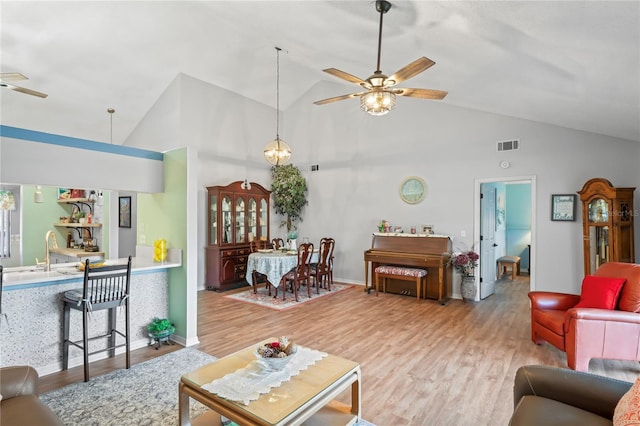 living room featuring sink, hardwood / wood-style flooring, high vaulted ceiling, and ceiling fan