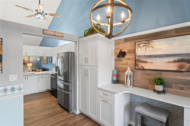 kitchen with lofted ceiling, range with electric cooktop, white cabinets, and stainless steel refrigerator with ice dispenser