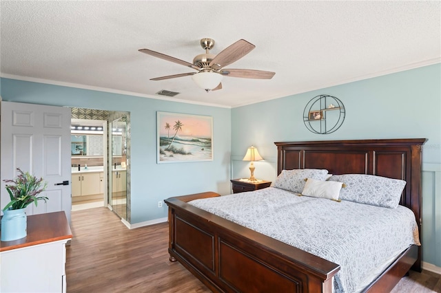 bedroom featuring ensuite bathroom, a textured ceiling, ornamental molding, dark hardwood / wood-style flooring, and ceiling fan