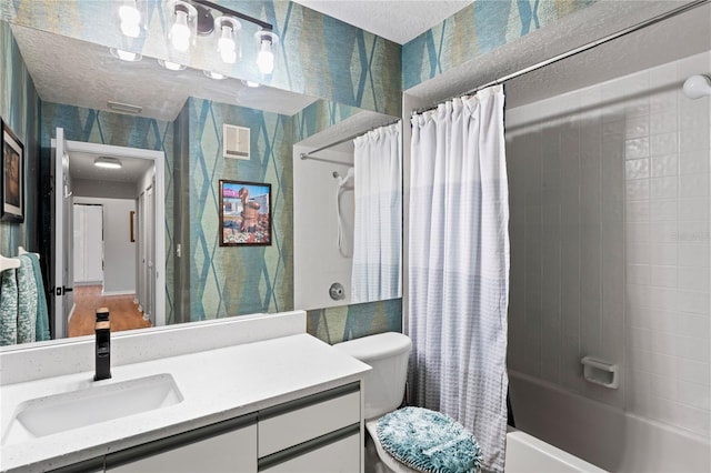 full bathroom featuring vanity, toilet, a textured ceiling, and shower / bath combo with shower curtain