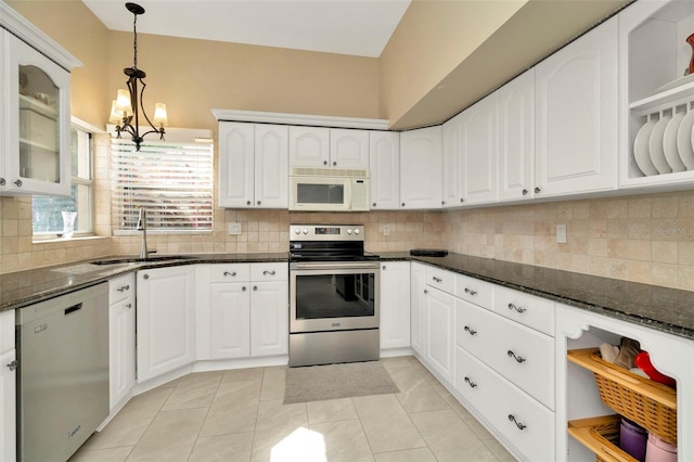 kitchen featuring sink, dark stone countertops, appliances with stainless steel finishes, pendant lighting, and white cabinets