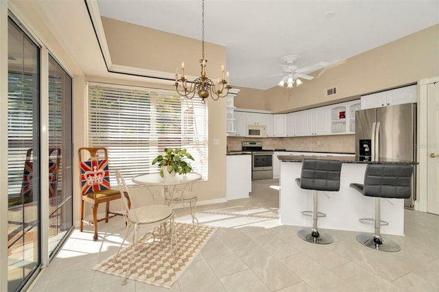 kitchen with white cabinetry, decorative backsplash, stainless steel appliances, and a kitchen island