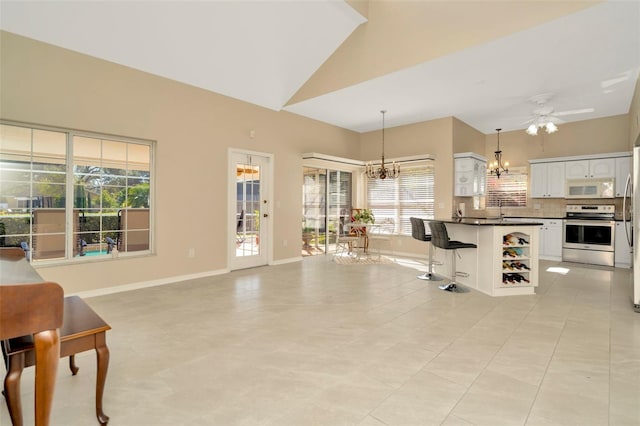 kitchen with pendant lighting, tasteful backsplash, white cabinetry, a breakfast bar area, and electric stove