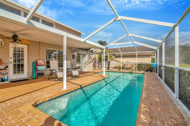 view of swimming pool featuring a patio area, ceiling fan, and glass enclosure