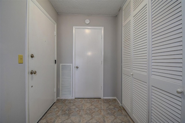 doorway to outside featuring a textured ceiling