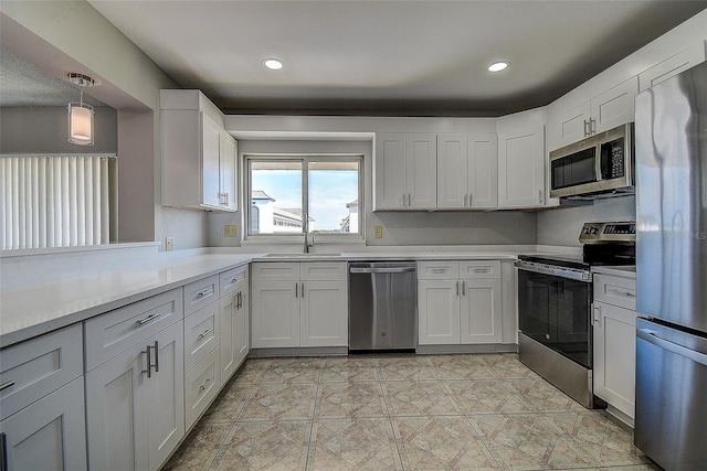 kitchen featuring stainless steel appliances, sink, hanging light fixtures, and white cabinets