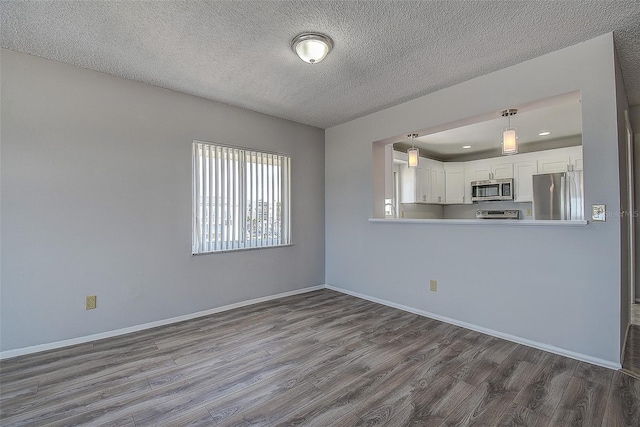 unfurnished living room with hardwood / wood-style flooring and a textured ceiling