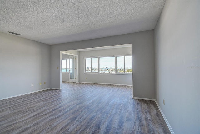 unfurnished room with wood-type flooring and a textured ceiling