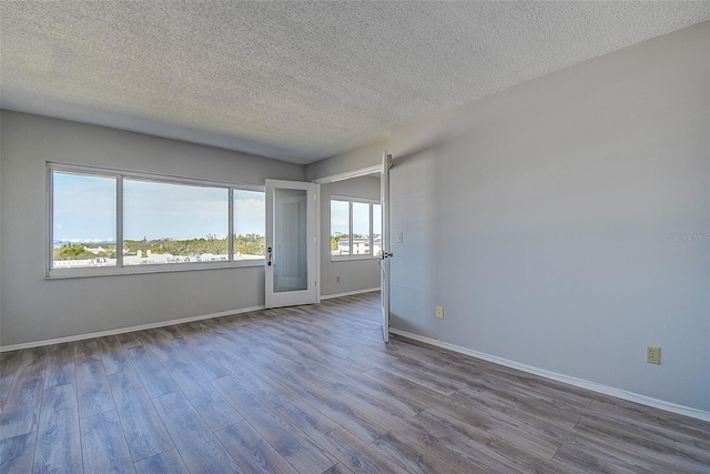 unfurnished room featuring a textured ceiling and light hardwood / wood-style floors