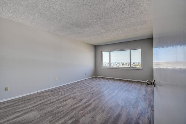 empty room with hardwood / wood-style flooring and a textured ceiling