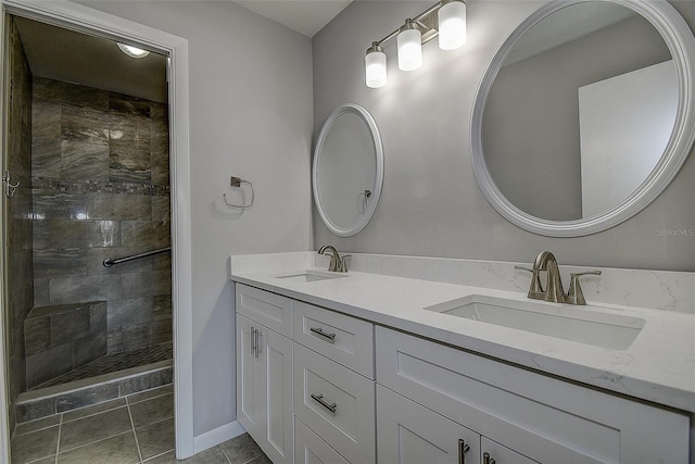 bathroom with vanity, tiled shower, and tile patterned floors