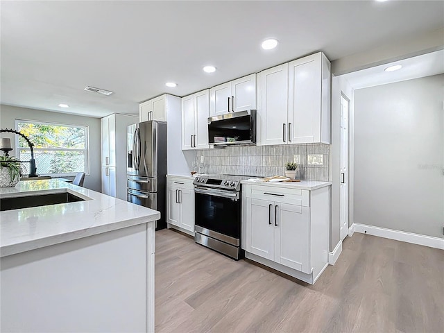 kitchen featuring white cabinetry, sink, light stone countertops, and appliances with stainless steel finishes