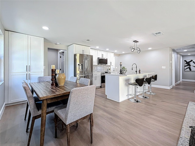 dining area featuring sink and light wood-type flooring