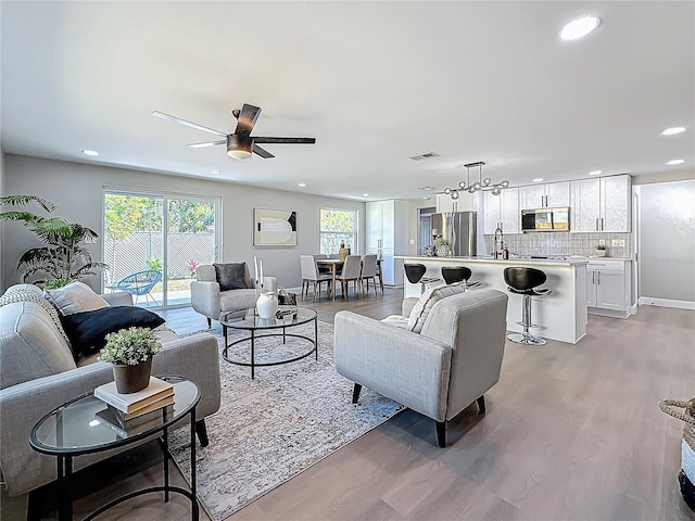 living room featuring ceiling fan and light wood-type flooring