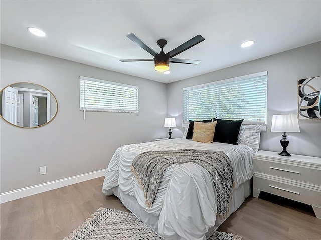 bedroom featuring multiple windows, light hardwood / wood-style flooring, and ceiling fan