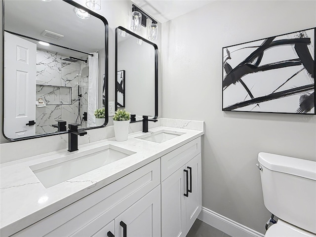 bathroom featuring vanity, a tile shower, and toilet