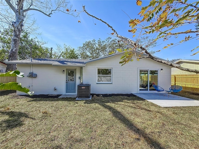 rear view of house featuring a patio area, central air condition unit, and a lawn