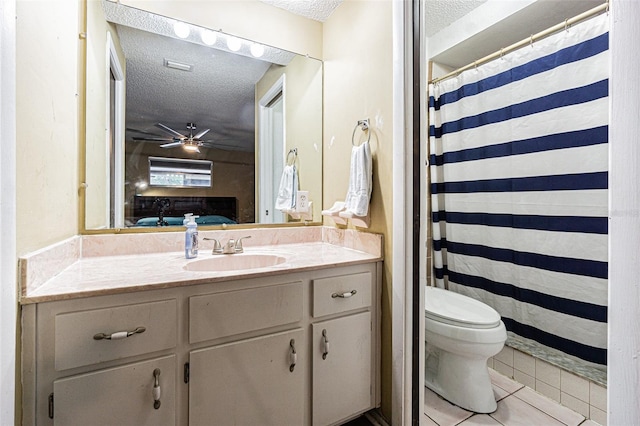 bathroom featuring ceiling fan, tile patterned flooring, vanity, a textured ceiling, and toilet