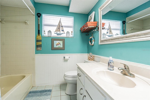 full bathroom with tile patterned floors, toilet, a textured ceiling, vanity, and tiled shower / bath combo