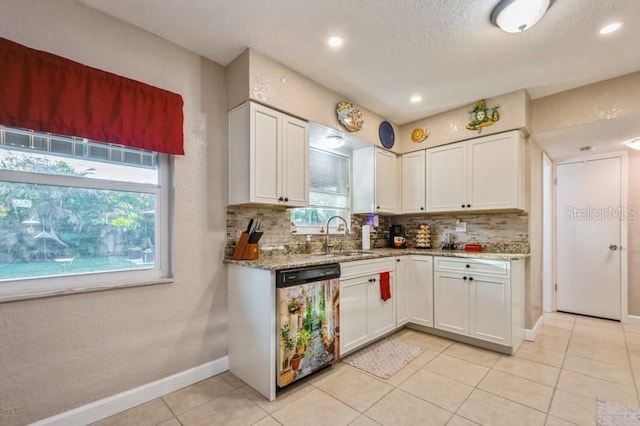 kitchen with sink, white cabinetry, light stone counters, tasteful backsplash, and stainless steel dishwasher