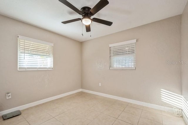 tiled spare room featuring ceiling fan