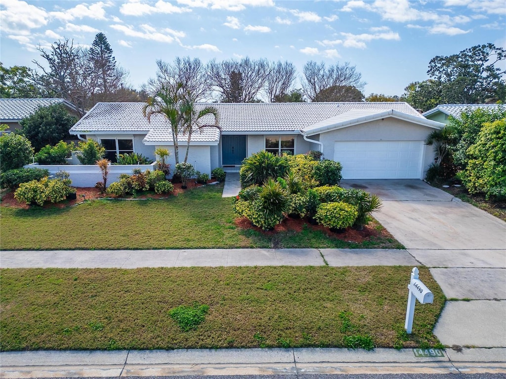 ranch-style home featuring a garage and a front yard