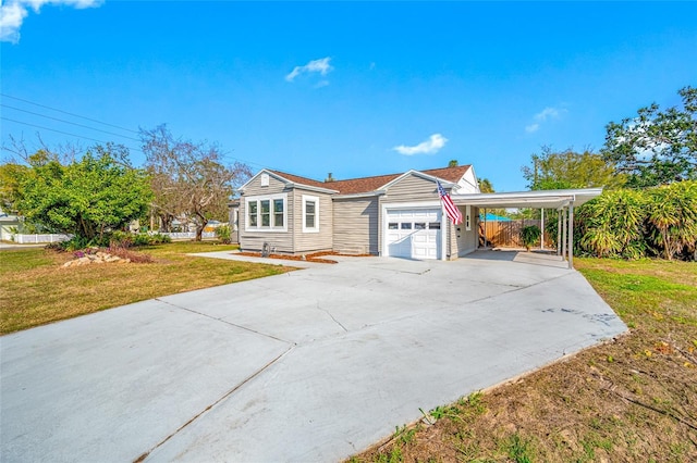 view of front of house with a carport, an attached garage, a front lawn, and concrete driveway