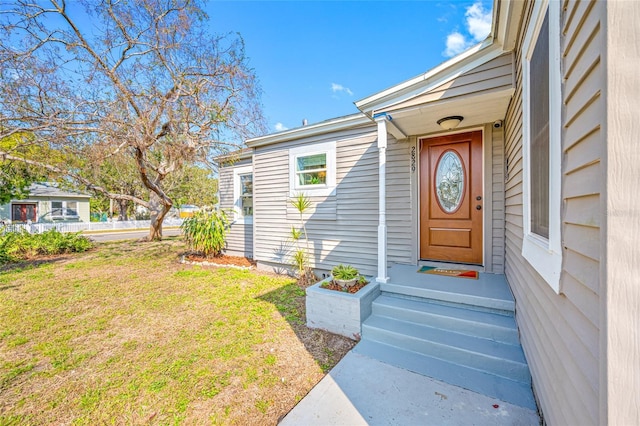 entrance to property with a lawn