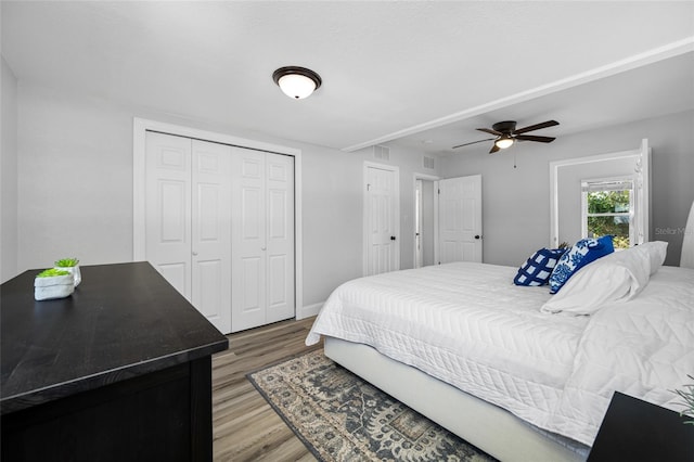 bedroom featuring wood-type flooring, a closet, and ceiling fan