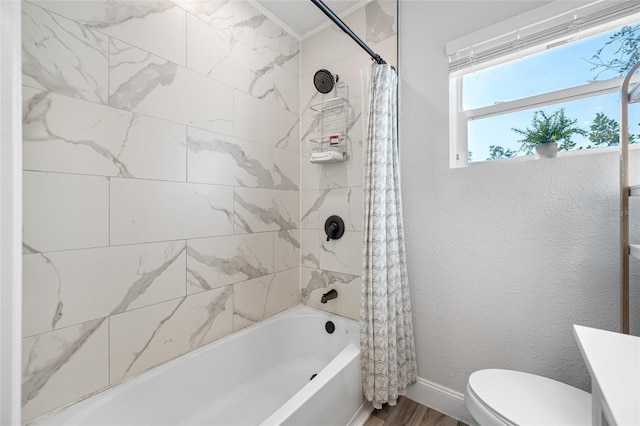 full bathroom featuring a textured wall, toilet, shower / bath combo with shower curtain, wood finished floors, and baseboards