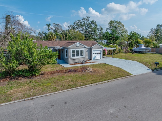 view of front of house with a front yard, concrete driveway, a chimney, and an attached garage