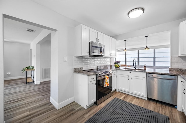 kitchen with light wood finished floors, visible vents, appliances with stainless steel finishes, and a sink