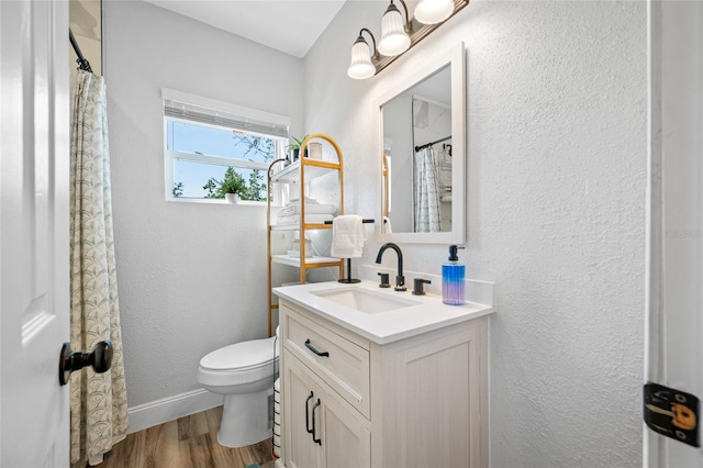 2829 9th Ave W, Bradenton, FL 34205 - bathroom with baseboards, toilet, a textured wall, vanity, and wood finished floors
