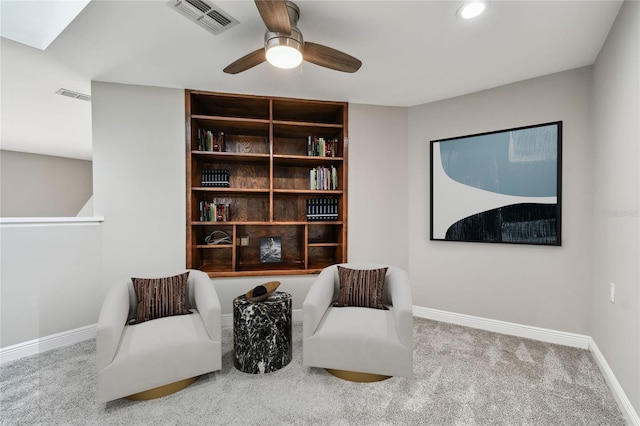 living area with light colored carpet and ceiling fan