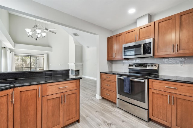 kitchen featuring light hardwood / wood-style flooring, a notable chandelier, pendant lighting, stainless steel appliances, and backsplash