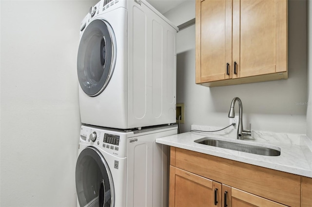 washroom with stacked washer / dryer, sink, and cabinets