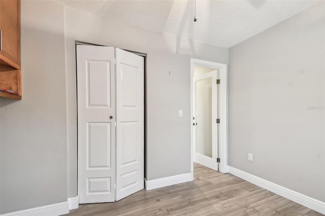 unfurnished bedroom with a closet and light wood-type flooring