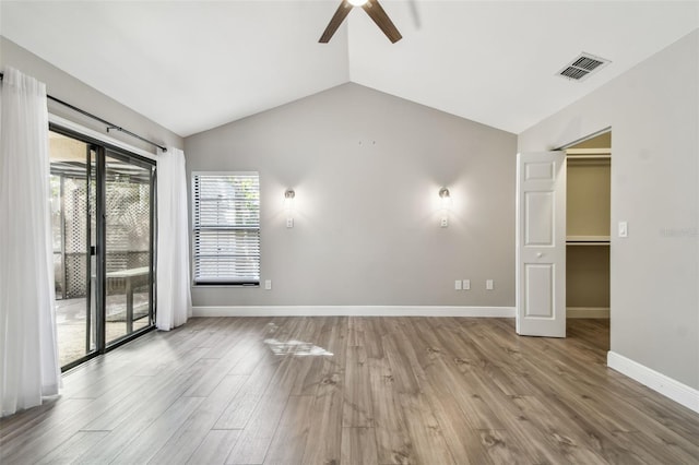 unfurnished room featuring ceiling fan, vaulted ceiling, and light wood-type flooring