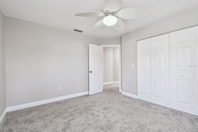 unfurnished bedroom featuring light colored carpet, ceiling fan, and a closet