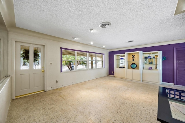 unfurnished living room featuring a textured ceiling