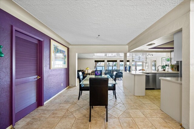 tiled dining room with sink and a textured ceiling