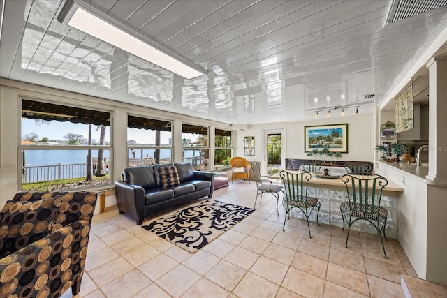 tiled living room with a water view and track lighting