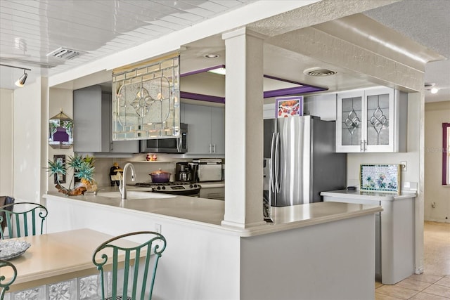 kitchen featuring sink, gray cabinetry, light tile patterned floors, appliances with stainless steel finishes, and kitchen peninsula